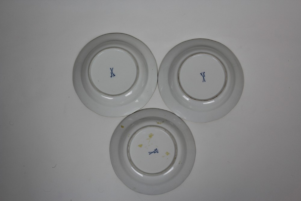 A set of three circular white porcelain dessert dishes featuring hand-painted birds and insects with basketweave moulded rims and gilt borders. View V