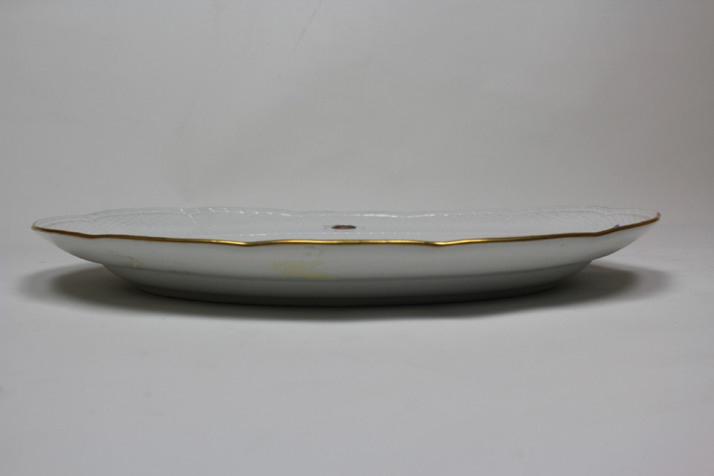 An oval white porcelain serving platter featuring a hand-painted yellow bird on a branch in the centre, surrounded by insect motifs on a basketweave rim with a gold edge. View III