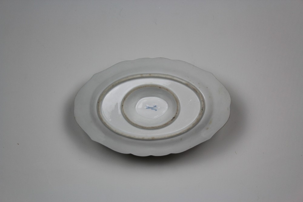 A white porcelain double-spouted sauce boat decorated with hand-painted bird and insect motifs, featuring gilded scalloped rims and an attached basketweave-moulded tray. View II