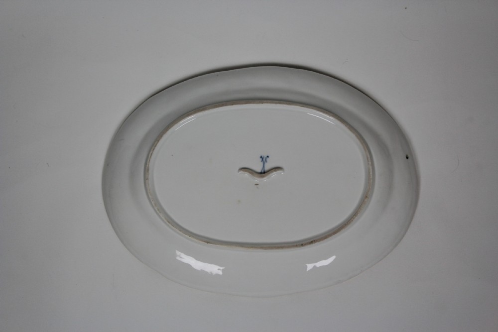 An oval white hard-paste porcelain platter featuring a hand-painted songbird on a branch in the centre, surrounded by painted insects and a gilded rim with a relief basketweave border. View III