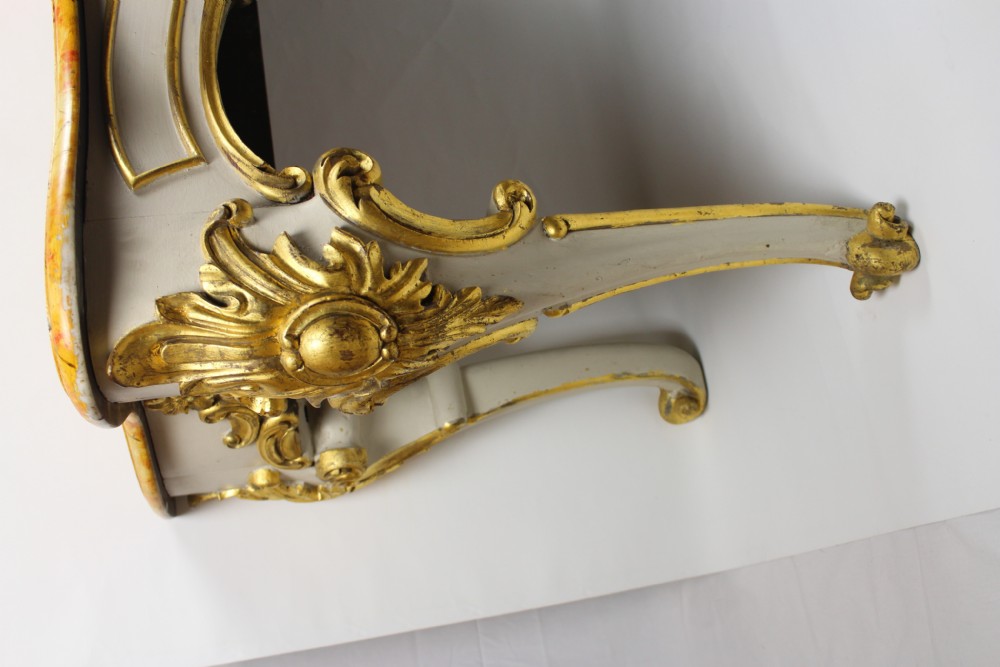 A French Louis XV style console table featuring a serpentine yellow sienna marble top over a grey painted frame decorated with giltwood acanthus carvings. View II