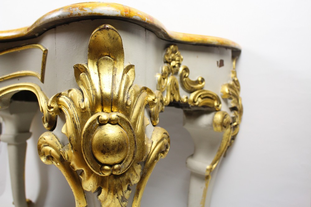 A French Louis XV style console table featuring a serpentine yellow sienna marble top over a grey painted frame decorated with giltwood acanthus carvings. View III