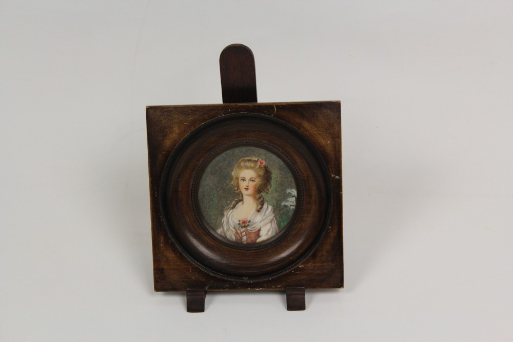 A pair of antique square dark wood framed portrait miniatures depicting two women dressed in historical attire. View II