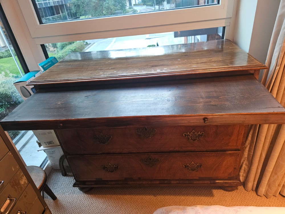 An 18th-century walnut chest of drawers featuring three crossbanded drawers, decorative pierced brass drop handles, keyhole escutcheons, and a sliding top panel. View II