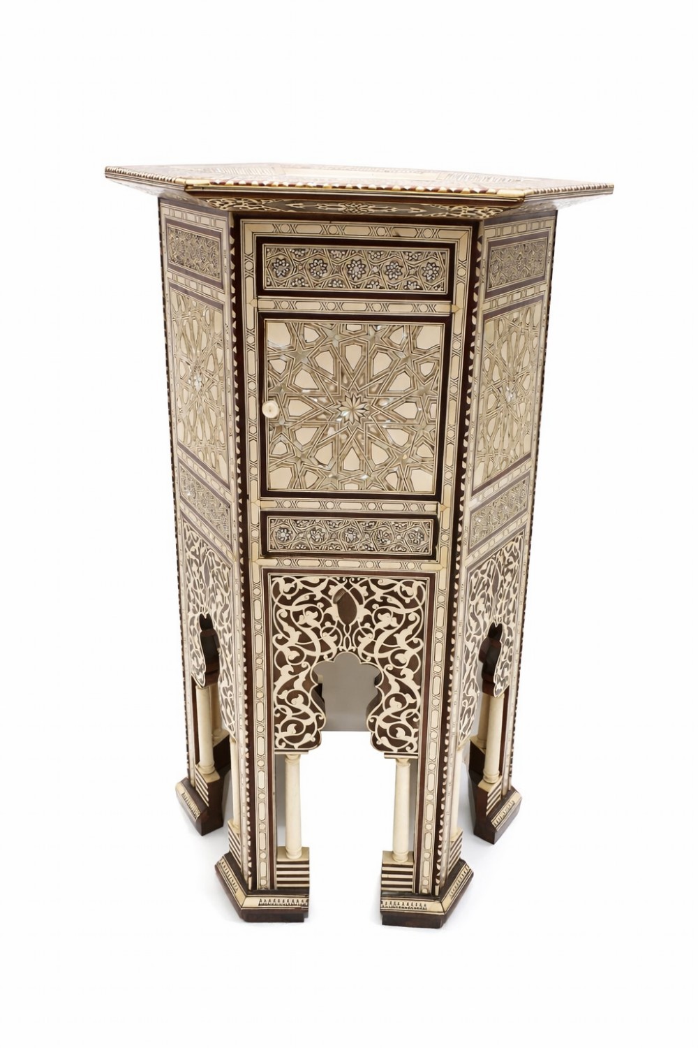 A 19th-century hexagonal side table featuring intricate geometric bone and mother-of-pearl inlay, a small central cupboard door, and arched lower apron supports.
