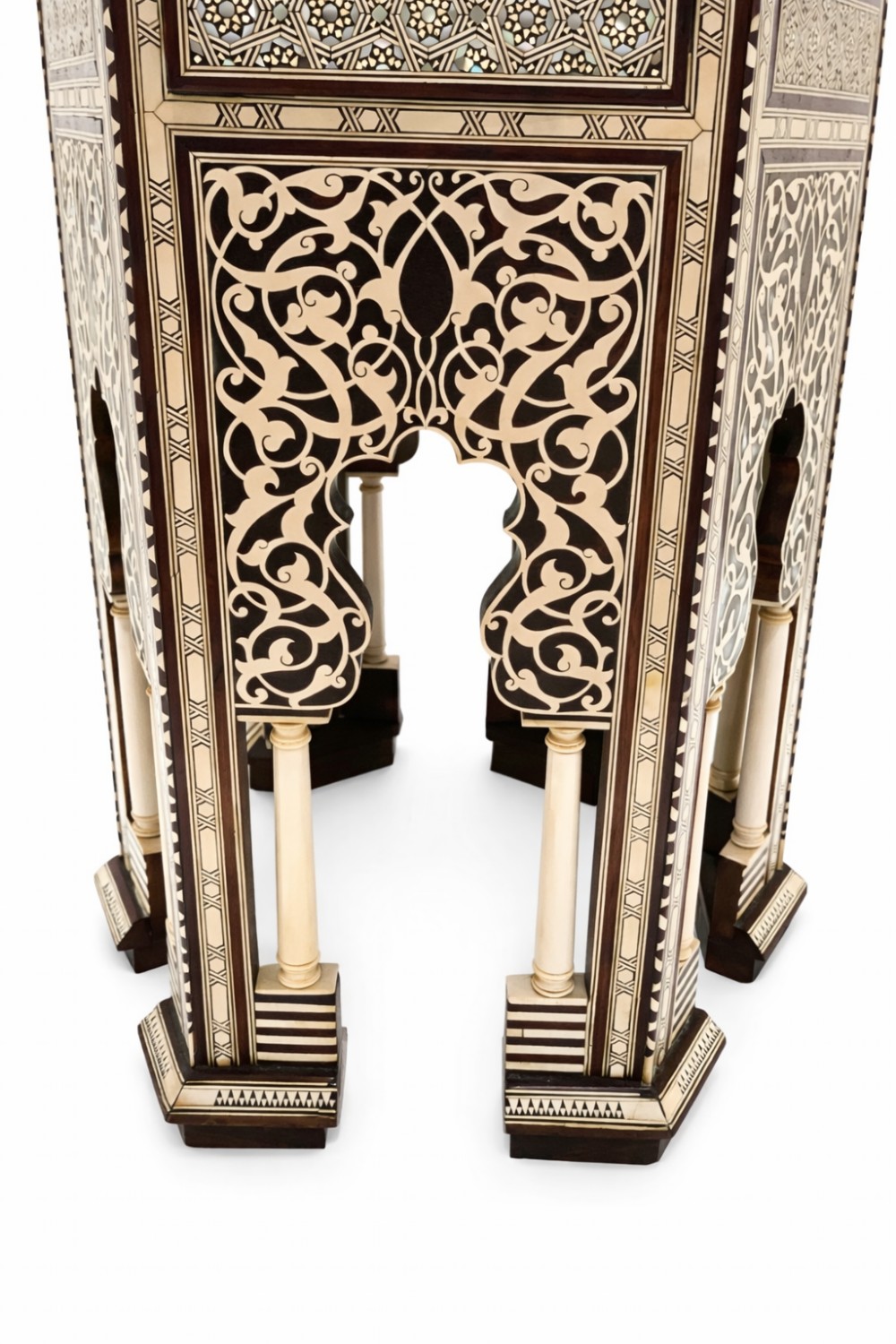 A 19th-century hexagonal side table featuring intricate geometric bone and mother-of-pearl inlay, a small central cupboard door, and arched lower apron supports. View IV