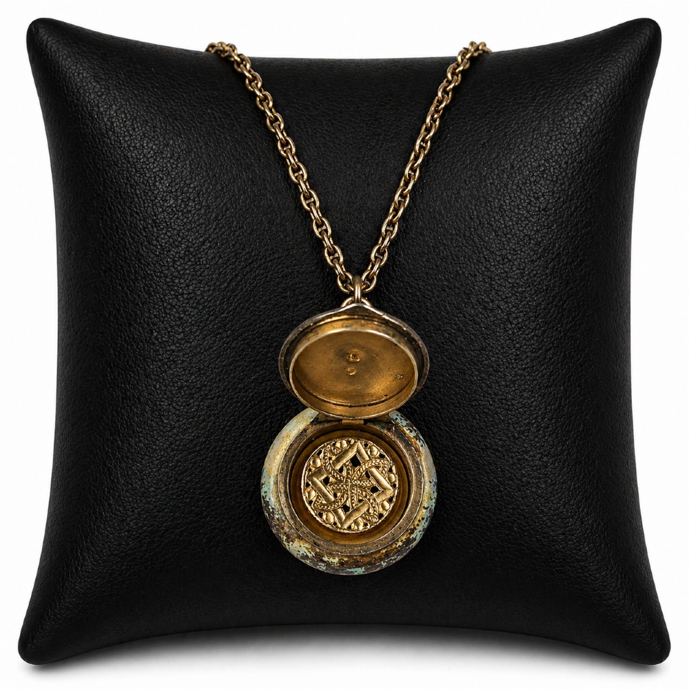 A circular double-sided enamel pendant necklace depicting a hand-painted scene of two figures in pastoral attire, set within a patterned silver border on a chain. View II