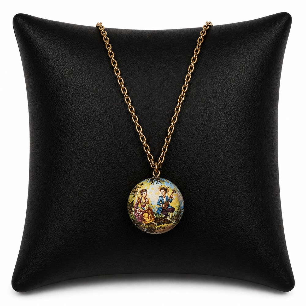 A circular double-sided enamel pendant necklace depicting a hand-painted scene of two figures in pastoral attire, set within a patterned silver border on a chain. View III