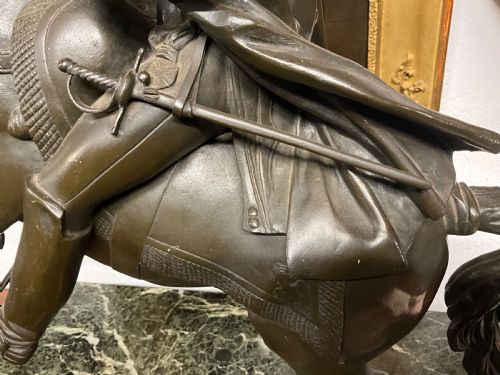 fig 1. A dark bronze sculpture depicting Napoleon Bonaparte mounted on a rearing horse, set on a rectangular green marble plinth.