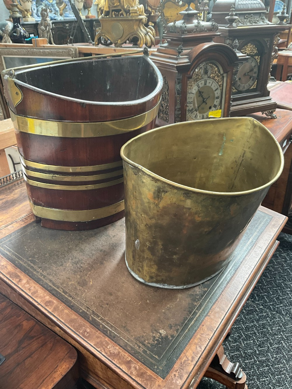 An early 19th-century elliptical mahogany bucket featuring horizontal brass banding, a brass swing handle, and a removable internal brass liner. View V