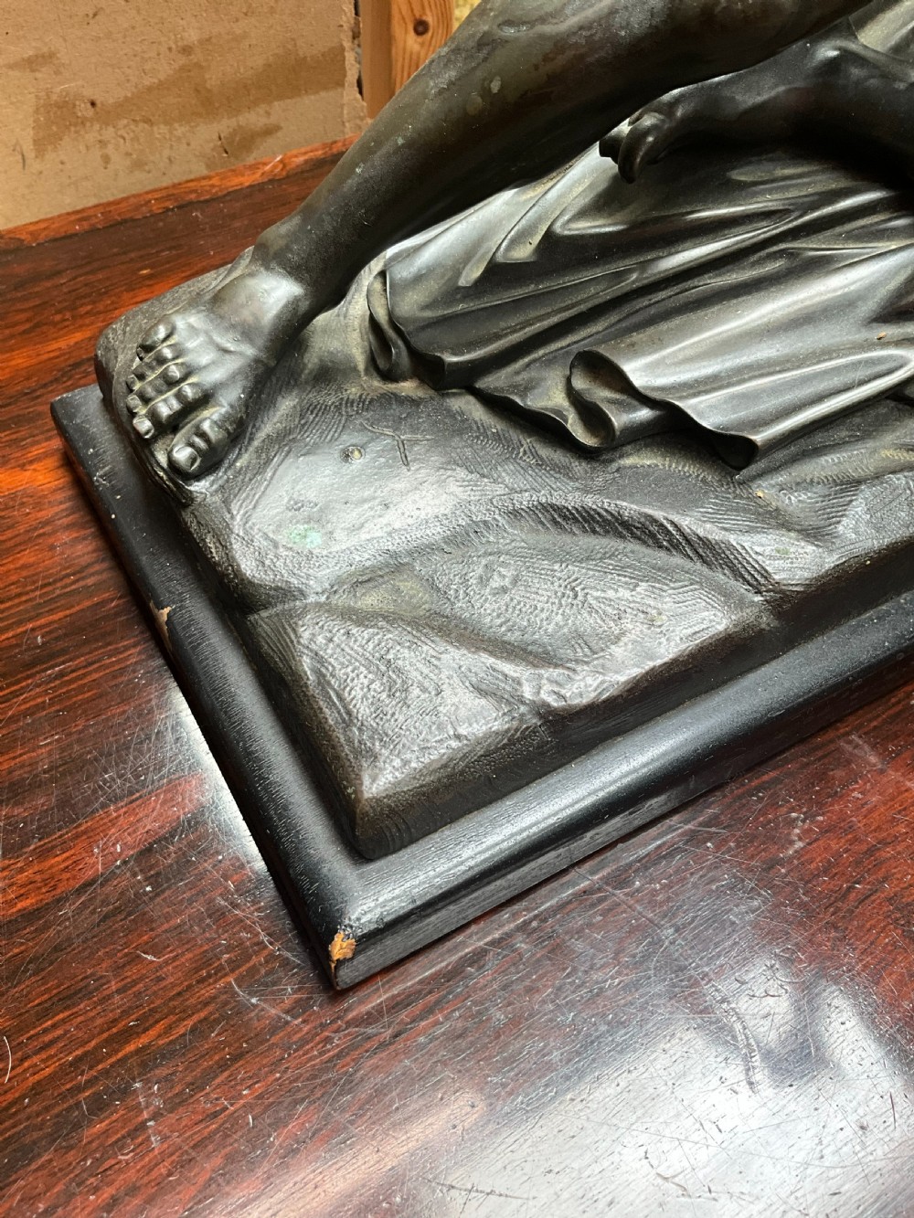 A patinated bronze sculpture depicting a semi-nude Classical soldier reclining on a rocky base with one arm raised aloft. View IV