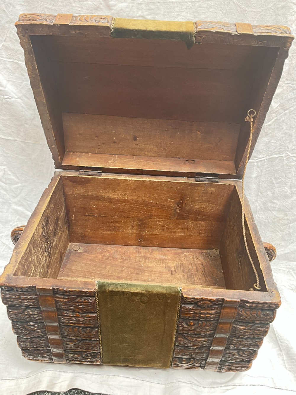 A dome-topped carved wooden box featuring a faux log bark texture with a central olive green velvet band. View VII