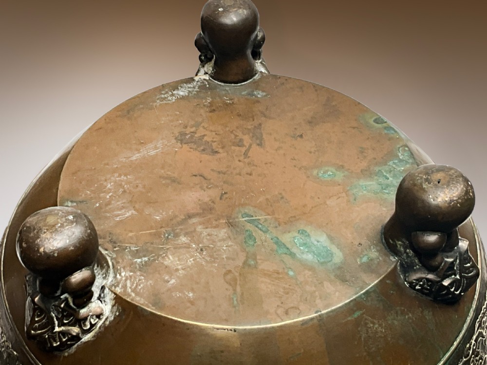 A pair of patinated bronze Oriental jardinieres featuring relief dragon carvings, scalloped rims, and tripod mask feet. View III