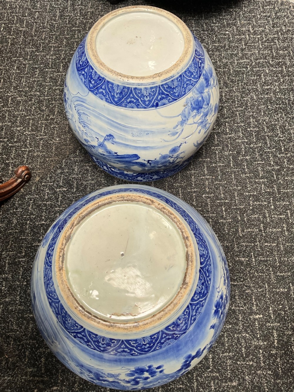 A pair of large round blue and white Japanese porcelain jardinieres decorated with avian motifs resting on intricately carved hardwood stands. View IV