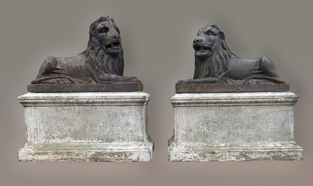 A pair of nineteenth-century salt-glazed stoneware recumbent lions resting on rectangular plinths with a distressed finish.