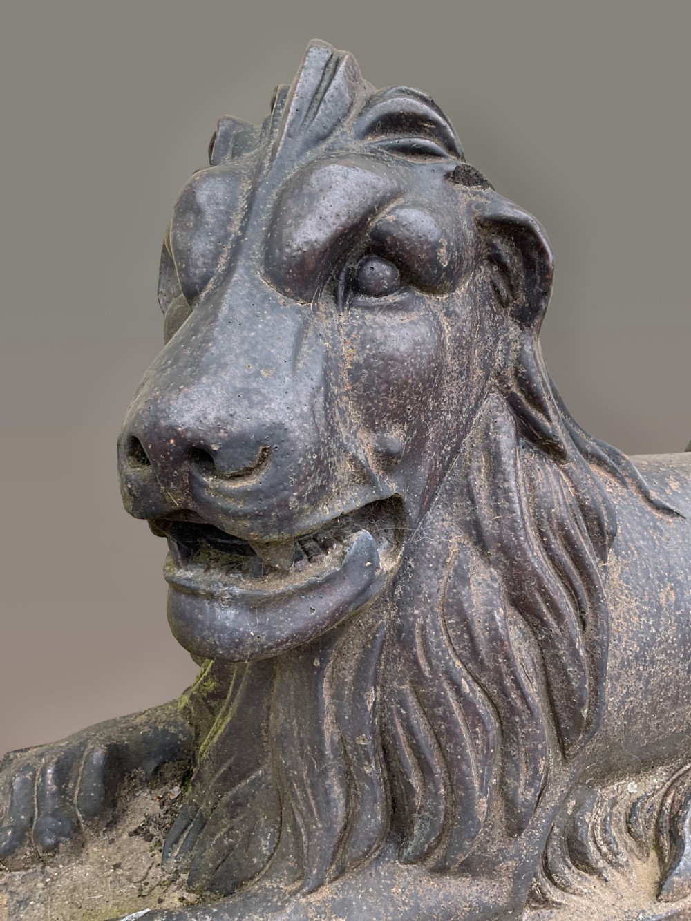 A pair of nineteenth-century salt-glazed stoneware recumbent lions resting on rectangular plinths with a distressed finish. View II