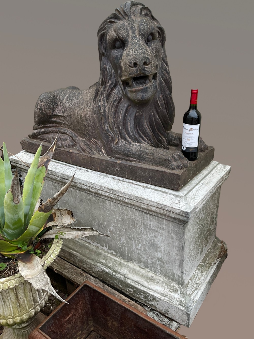 A pair of nineteenth-century salt-glazed stoneware recumbent lions resting on rectangular plinths with a distressed finish. View III