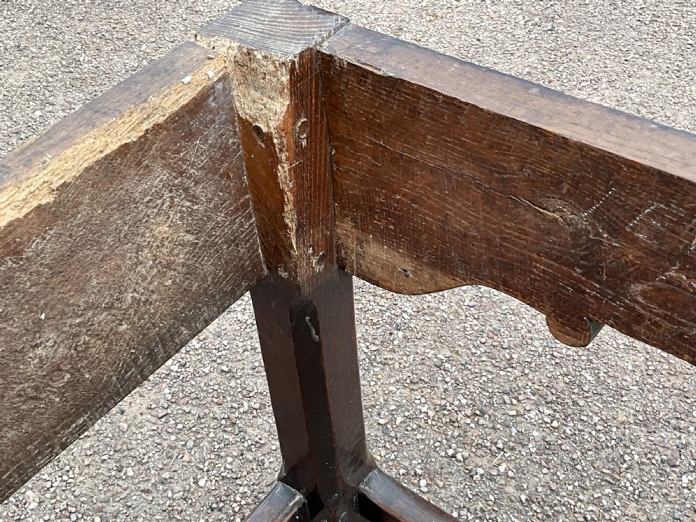 A long English oak refectory dining table featuring a three-plank top, breadboard ends, apron spandrels, and a low stretcher base. View VI