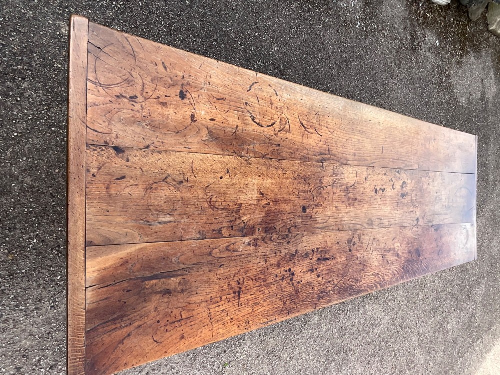 A long English oak refectory dining table featuring a three-plank top, breadboard ends, apron spandrels, and a low stretcher base. View VIII