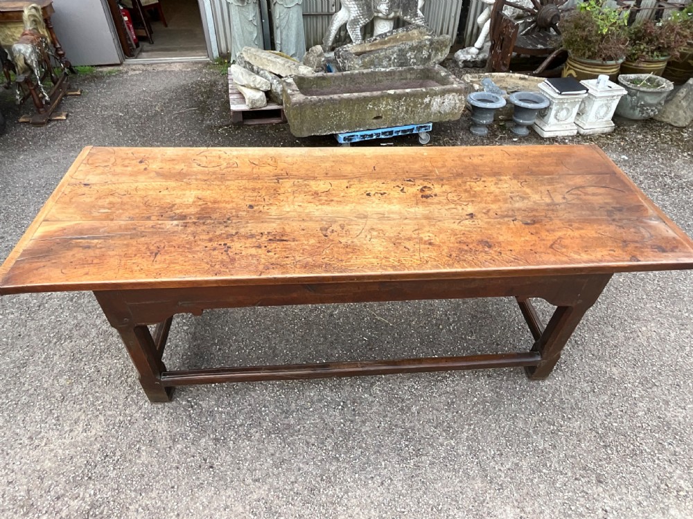 A long English oak refectory dining table featuring a three-plank top, breadboard ends, apron spandrels, and a low stretcher base. View XIII