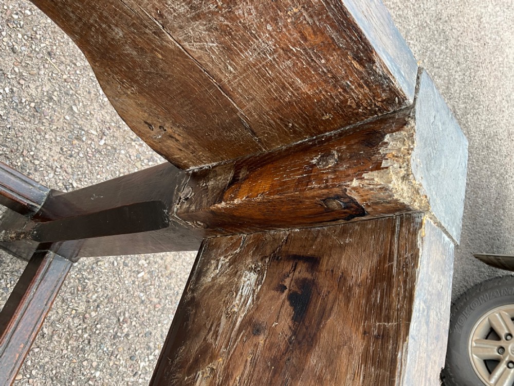 A long English oak refectory dining table featuring a three-plank top, breadboard ends, apron spandrels, and a low stretcher base. View XVI