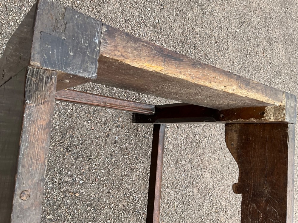 A long English oak refectory dining table featuring a three-plank top, breadboard ends, apron spandrels, and a low stretcher base. View XVIII