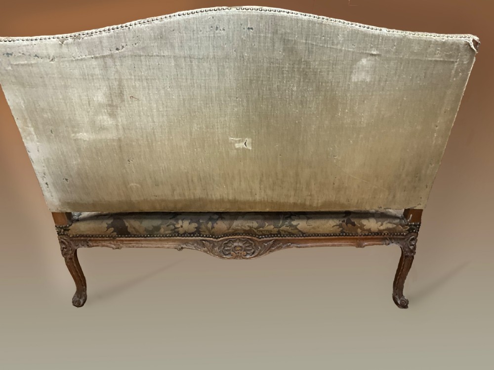 An 18th-century French carved wooden settee upholstered in a historic landscape and floral tapestry. View II