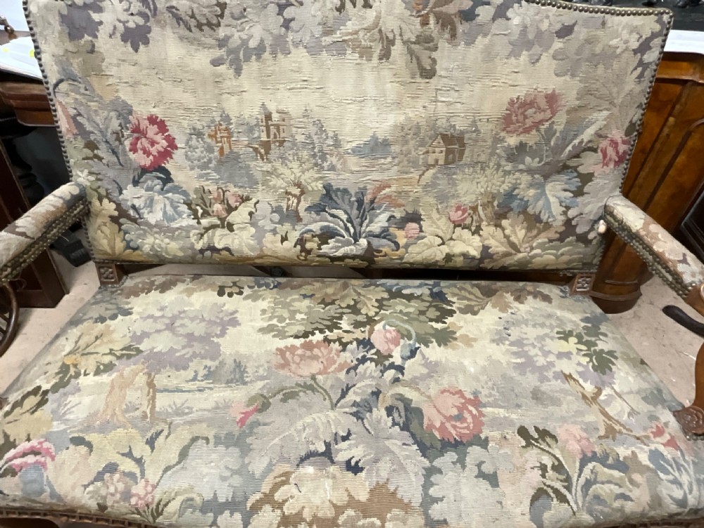 An 18th-century French carved wooden settee upholstered in a historic landscape and floral tapestry. View III