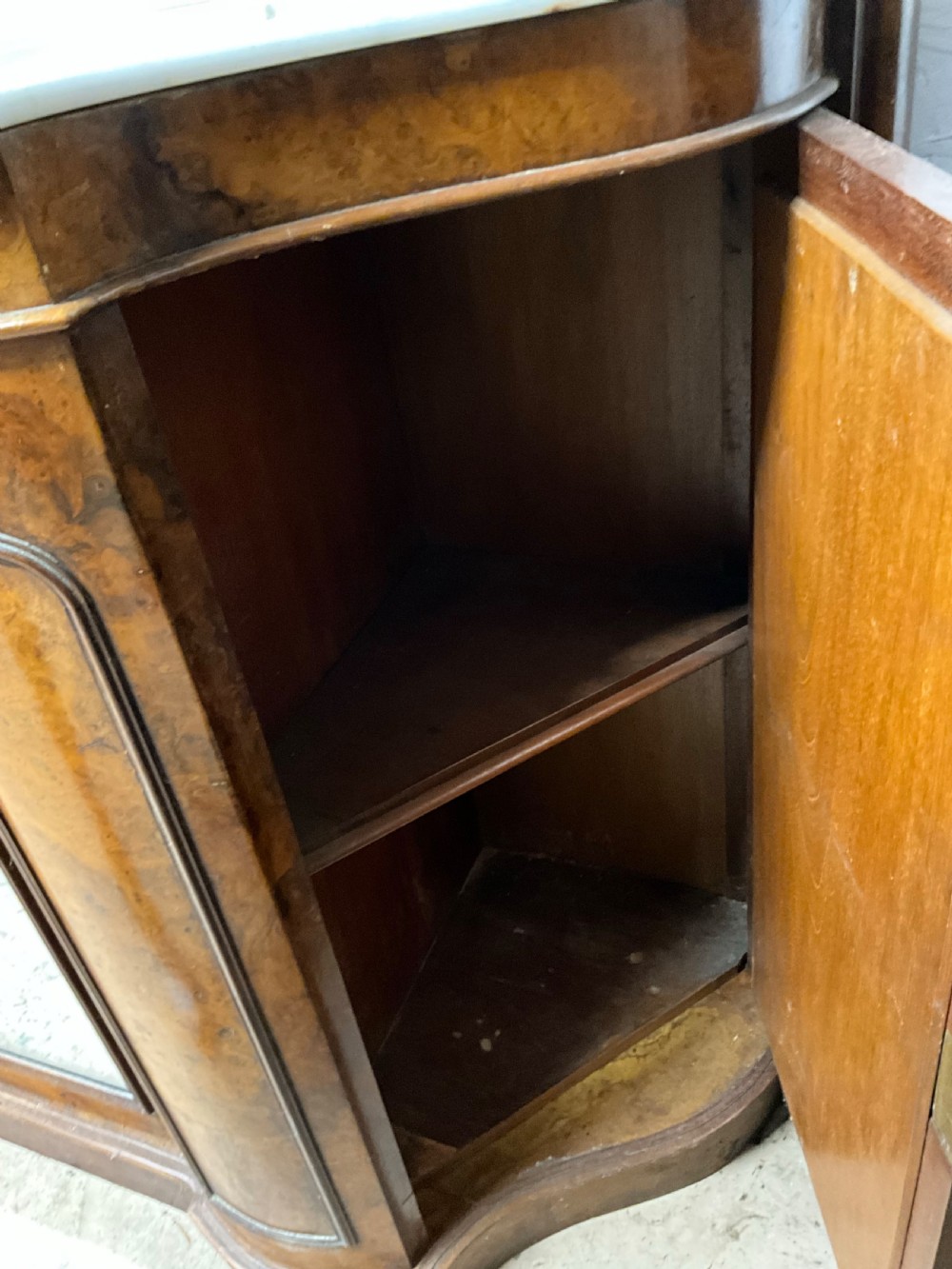 A 19th-century Victorian burr walnut credenza with a white marble top, mirrored front panels, and a carved arching mirror frame top. View IV