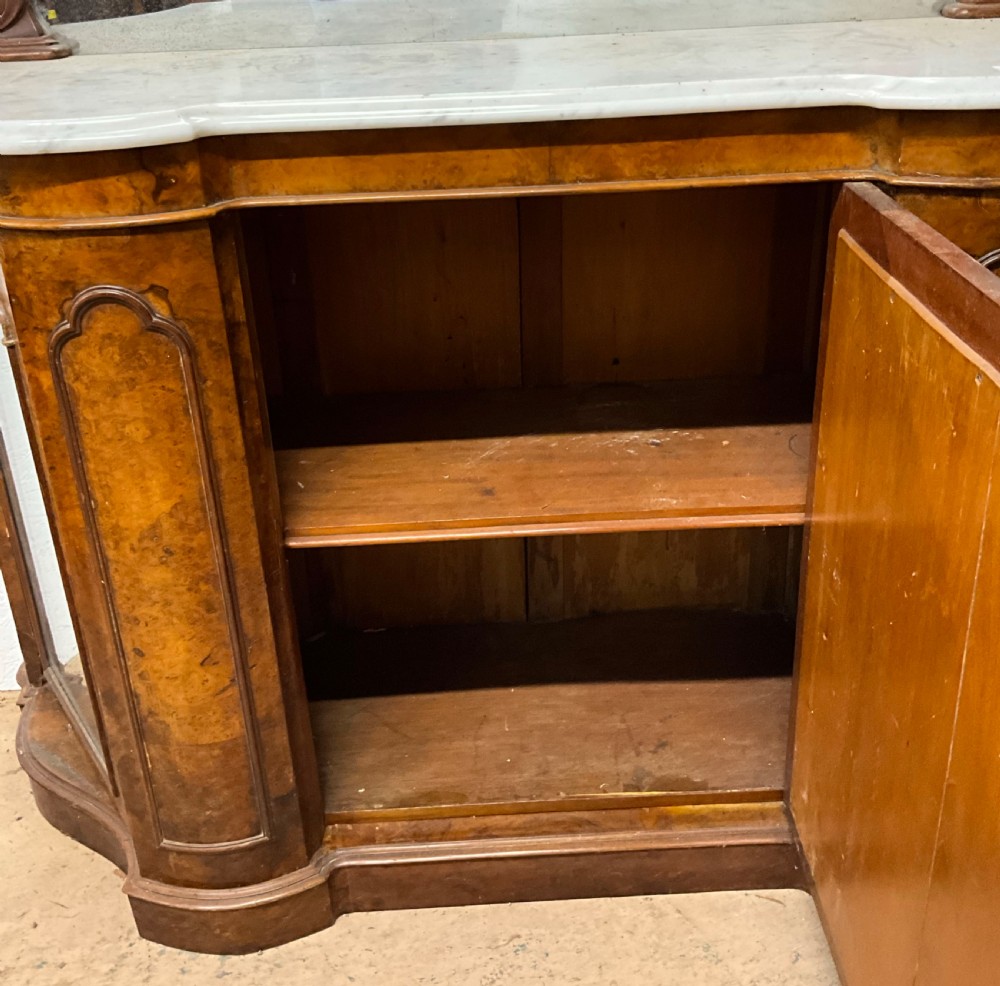 A 19th-century Victorian burr walnut credenza with a white marble top, mirrored front panels, and a carved arching mirror frame top. View V