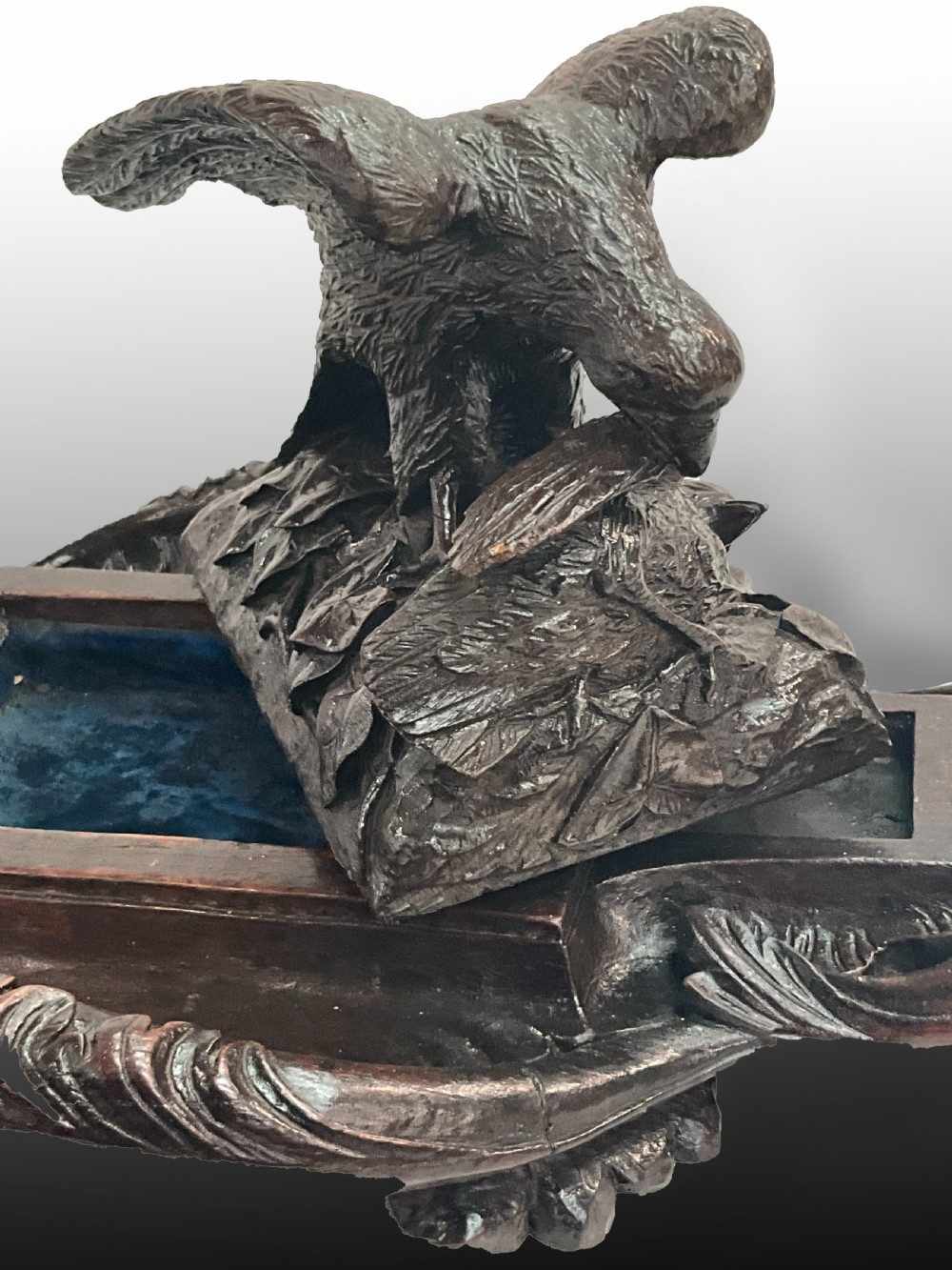 A carved dark wood Black Forest inkstand featuring a central eagle figure perched over prey, flanked by two square glass inkwells. View VI