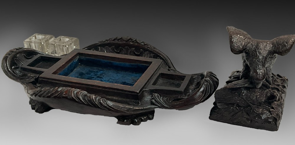 A carved dark wood Black Forest inkstand featuring a central eagle figure perched over prey, flanked by two square glass inkwells. View VII