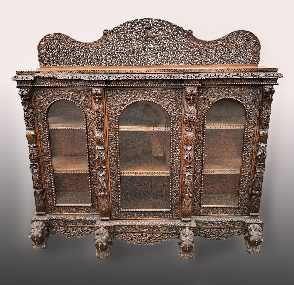 A heavily carved Burmese glazed breakfront library bookcase