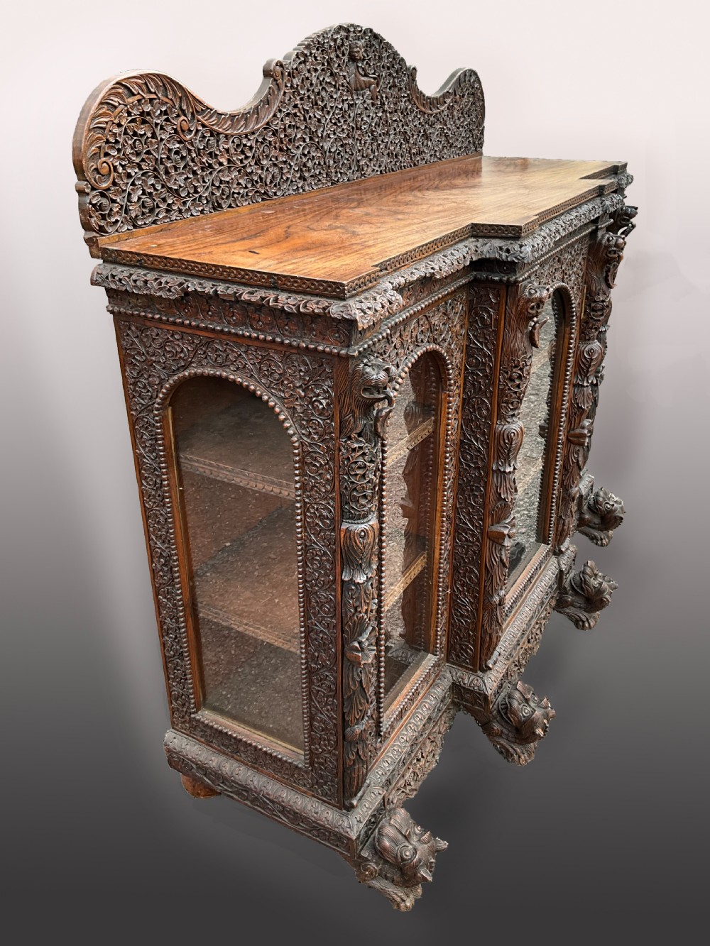A heavily carved Burmese glazed breakfront library bookcase View II