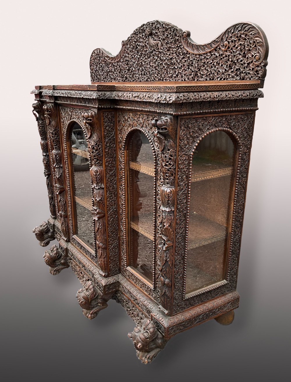 A heavily carved Burmese glazed breakfront library bookcase View V