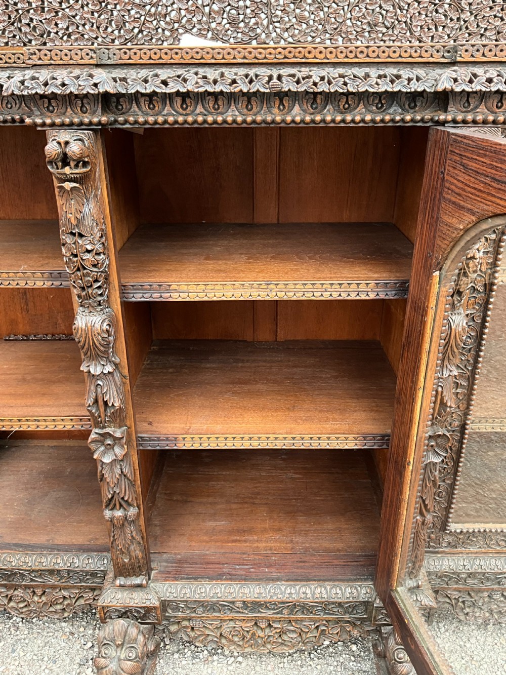 A heavily carved Burmese glazed breakfront library bookcase View VII