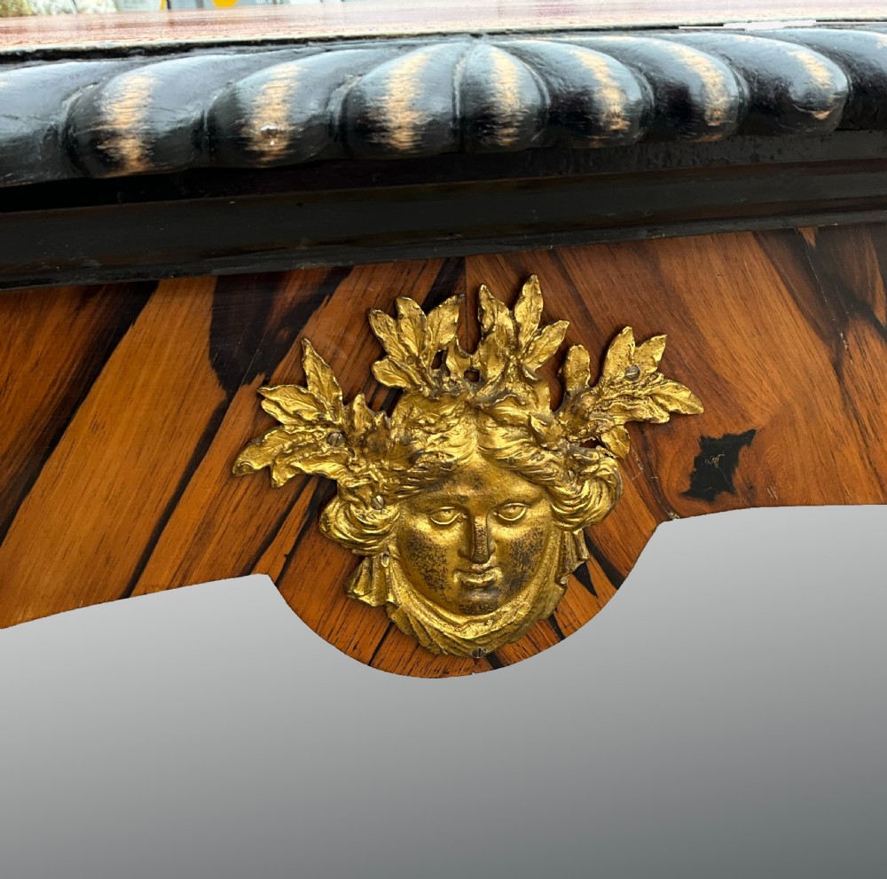 A French zebrawood writing table featuring a red leather top with gilt tooling, curved cabriole legs, and ornate gold-coloured mounts. View IV