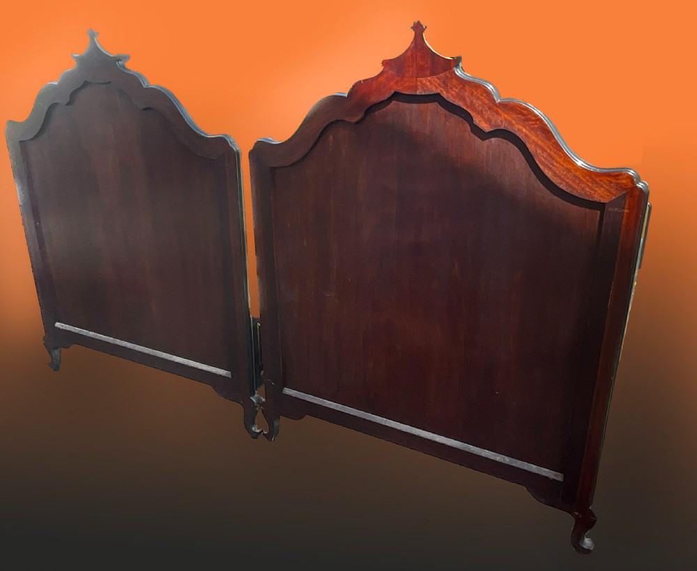 A pair of black lacquered single bed frames decorated with gold painted East Asian landscape scenes, figures, and shaped pagoda headboards. View V