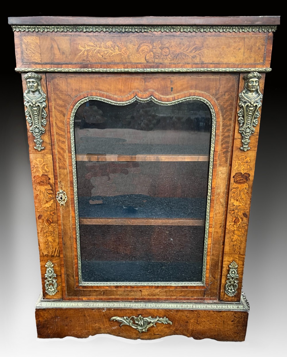 A Victorian burr walnut glazed cabinet featuring floral marquetry inlays, metal mounts, and a single glass door.