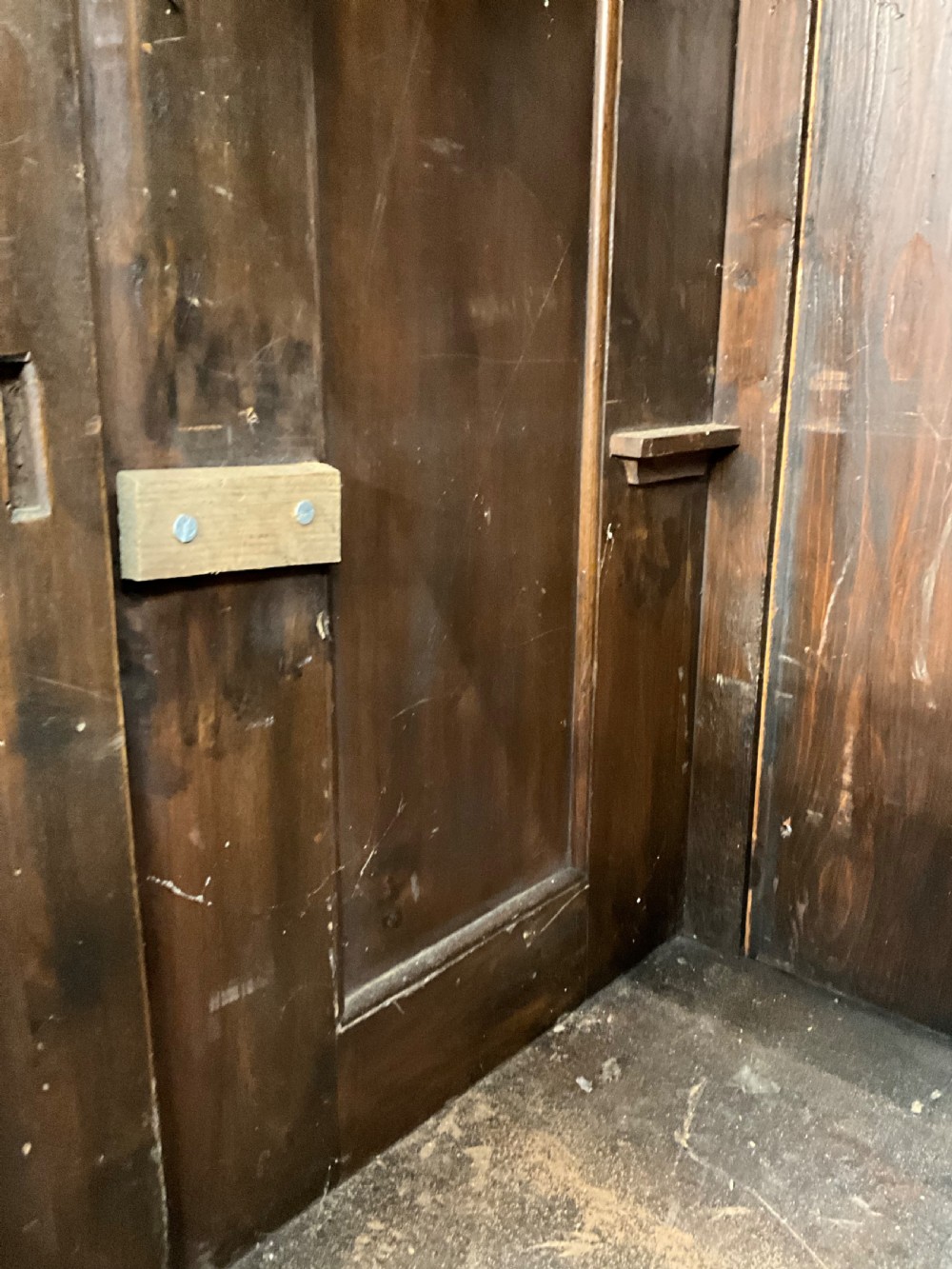 A tall dark walnut cabinet featuring detailed classical relief carvings on two door panels flanked by turned columns. View XII