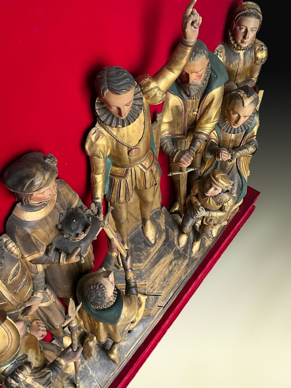 A mid-19th-century carved and gilded wooden figure group depicting multiple Renaissance figures against a red velvet backing. View IV