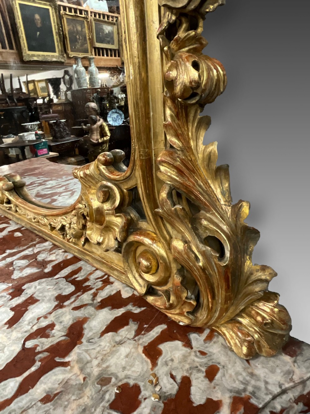 An ornate French Rococo giltwood console table featuring a shaped red marble top and a matching carved mirror frame with foliage cresting. View IV