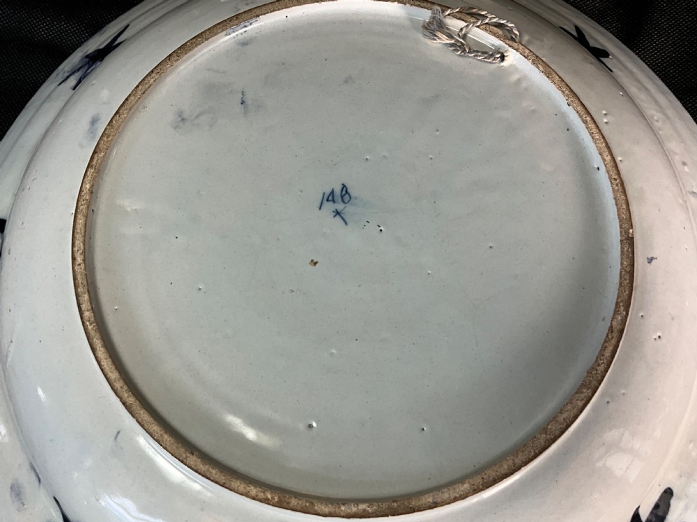 An 18th-century circular Delftware plate featuring hand-painted cobalt blue chinoiserie figures and floral panelled borders on a tin-glazed background. View III