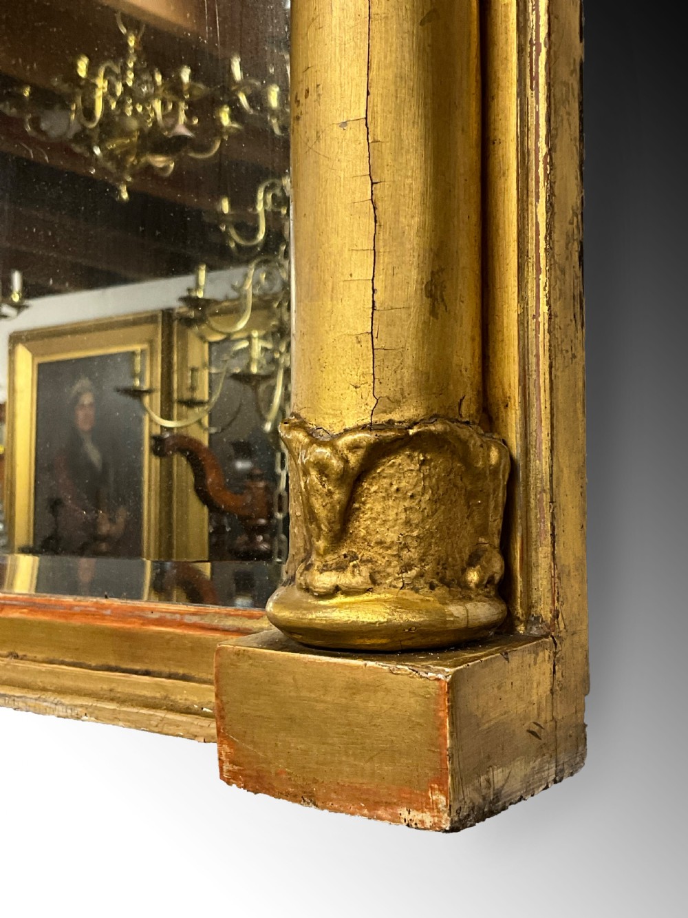 An early 19th-century Regency gilded overmantel mirror featuring a triple-plate mirror design, fluted columns, and ball moulding details. View V