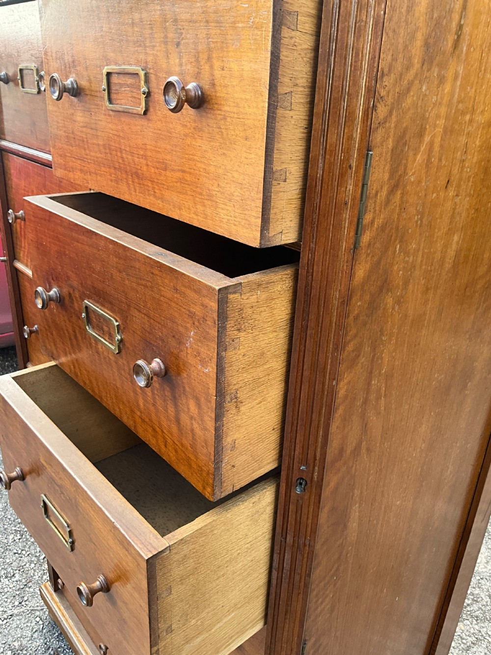 A tall 19th-century walnut bank of sixteen drawers featuring central brass label holders, turned wooden knobs, and a spindle gallery top rail. View II