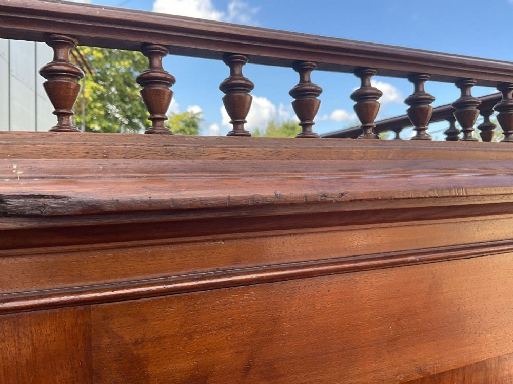 A tall 19th-century walnut bank of sixteen drawers featuring central brass label holders, turned wooden knobs, and a spindle gallery top rail. View IV