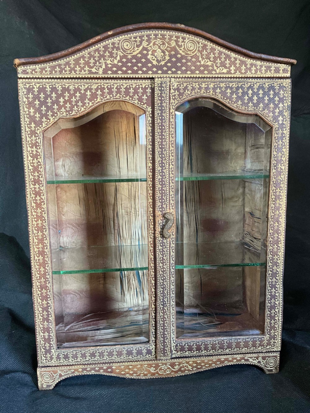 A miniature leather and gilt bound display cabinet. Circa 1880.