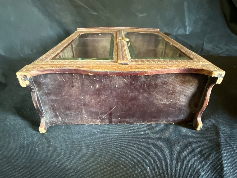 A miniature leather and gilt bound display cabinet. Circa 1880. View II