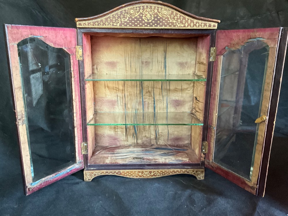 A miniature leather and gilt bound display cabinet. Circa 1880. View VII
