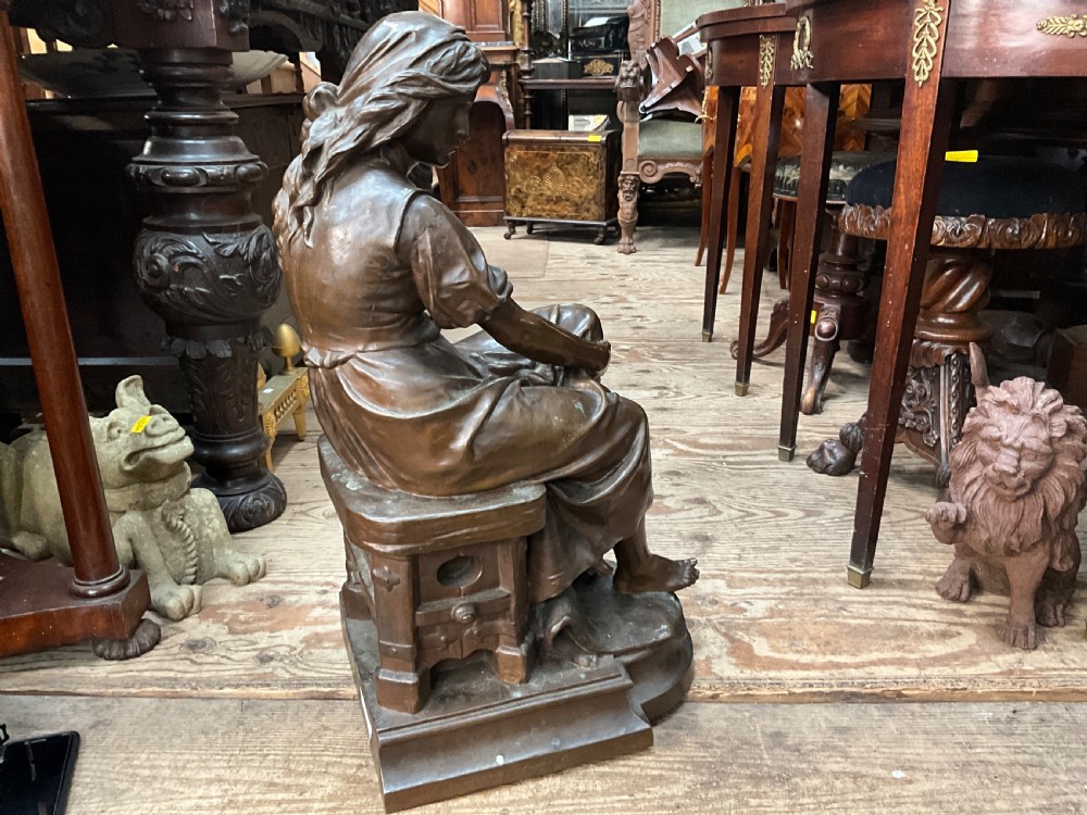 A dark patinated bronze statue depicting a seated young woman resting her foot on a rock next to a lute, with Mignon inscribed on the base. View VIII